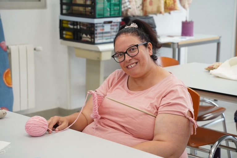 mujer sonriendo con ovillo de lana